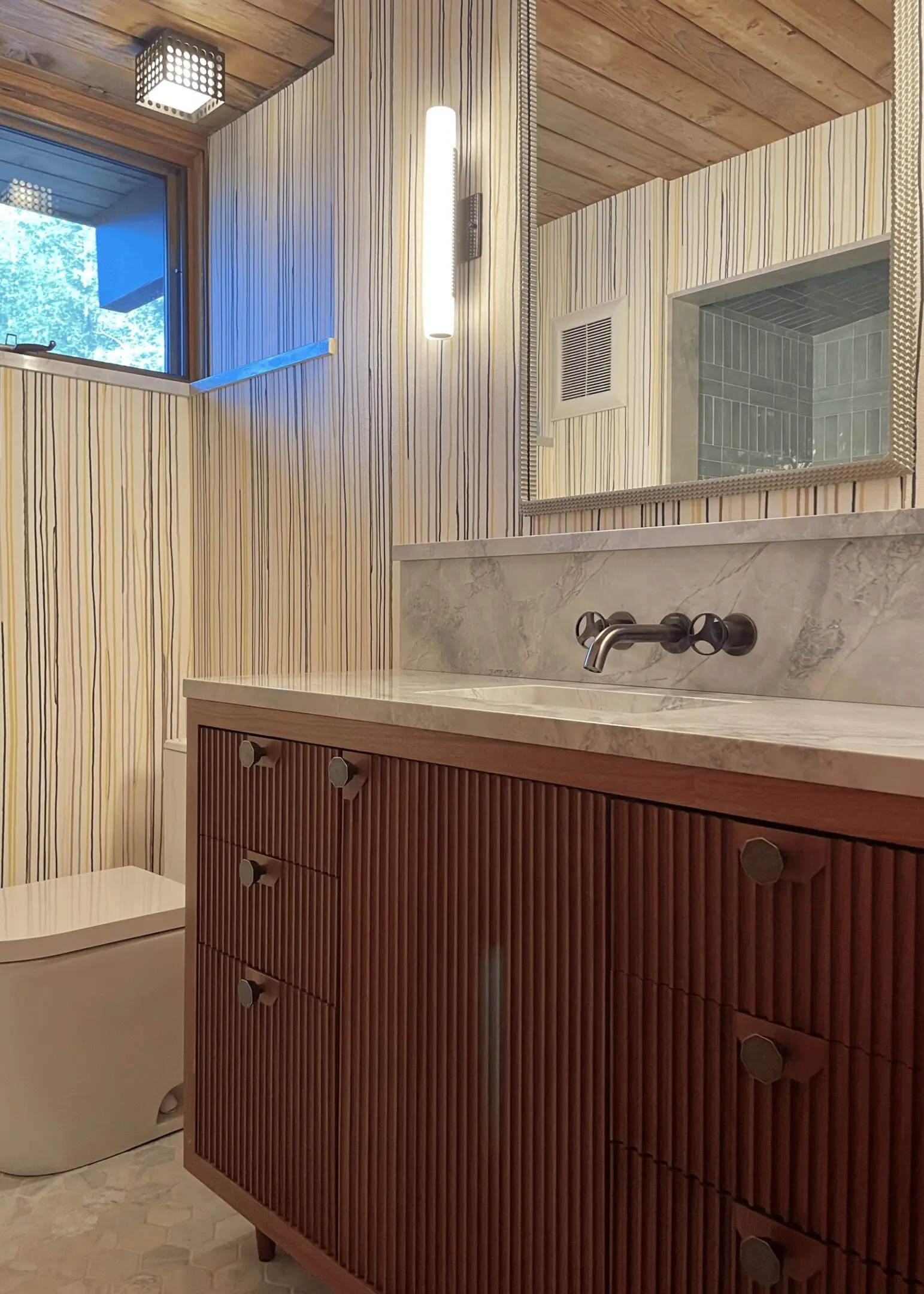 A bathroom with wood paneling and white walls.